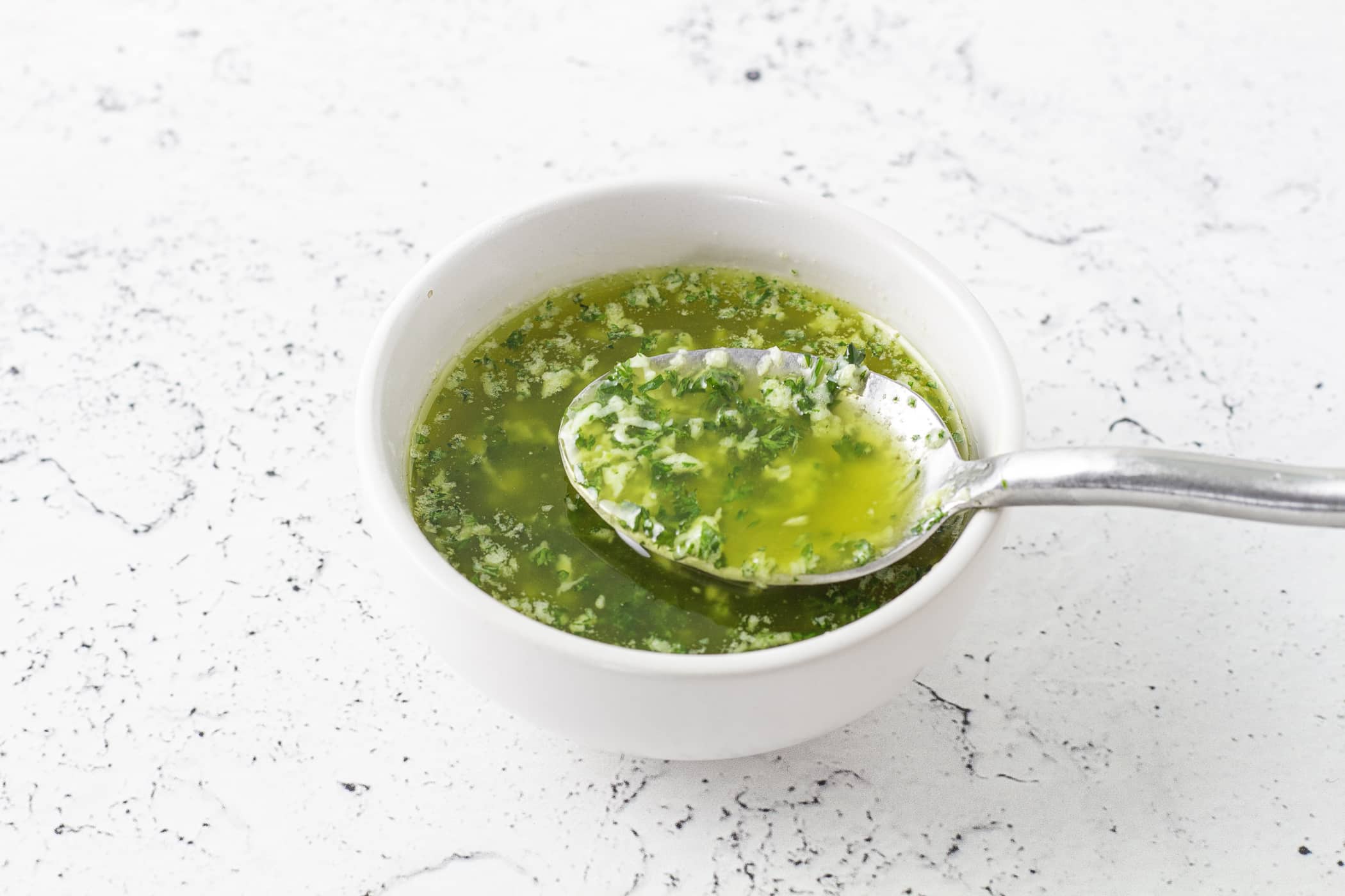 Melted butter with minced garlic gently bubbling in a small saucepan on a stovetop